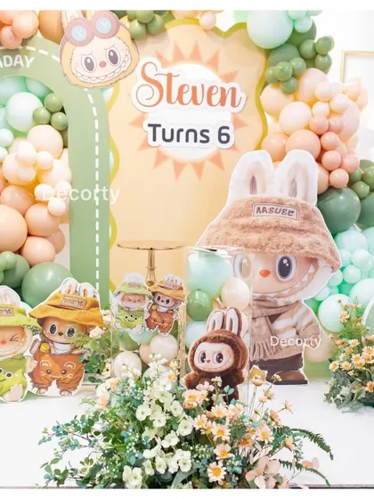 A close-up of the centerpiece for a 'Labubu' themed birthday party, featuring the popular character and floral arrangements.