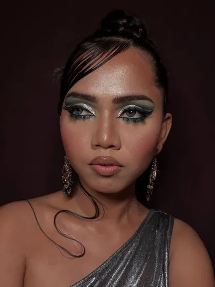 Another angle of this edgy editorial look, showing how the light catches the metallic green eyeshadow and the glossy finish on the skin.