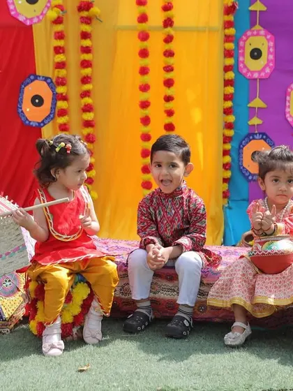 Three little friends dressed in colorful traditional attire, enjoying the festive atmosphere of our Baisakhi celebration. These moments of shared joy are what we cherish.