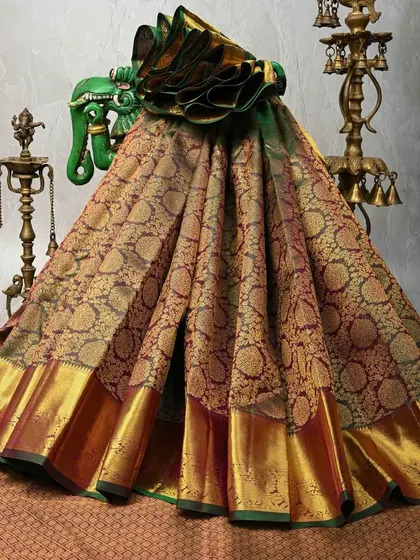 This is a masterpiece of weaving. A rich brocade Kanjivaram silk saree with intricate floral and paisley patterns woven all over the body in gold zari. This is a true bridal or heirloom saree.