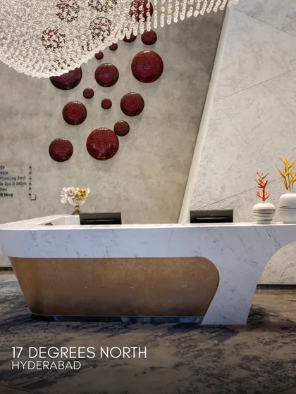 The reception desk at 17 Degrees North, featuring a parametric form and a backdrop of artistic wall installations. This area sets the tone for the club's modern-vintage theme, blending innovative design with classic luxury.
