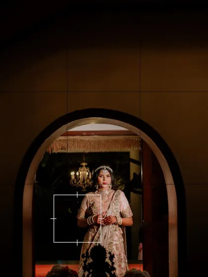 An artistic shot of the bride framed in an archway, looking like a classic painting.