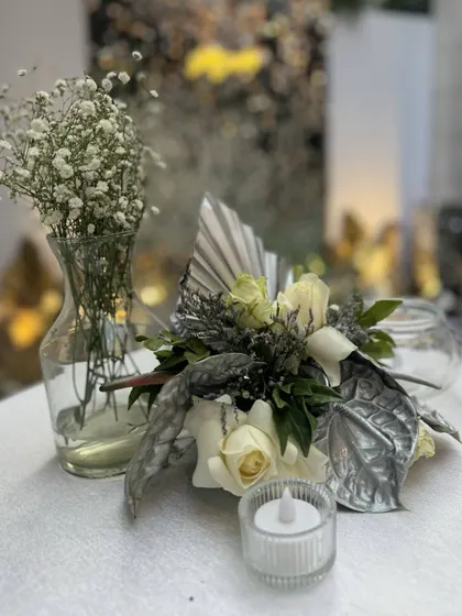 A similar centerpiece from a different angle, showing the delicate balance of textures and the soft glow of the flameless candles.