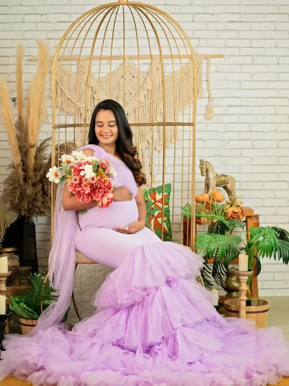 A joyful portrait of the mom-to-be holding a bouquet of flowers, her smile lighting up the frame.