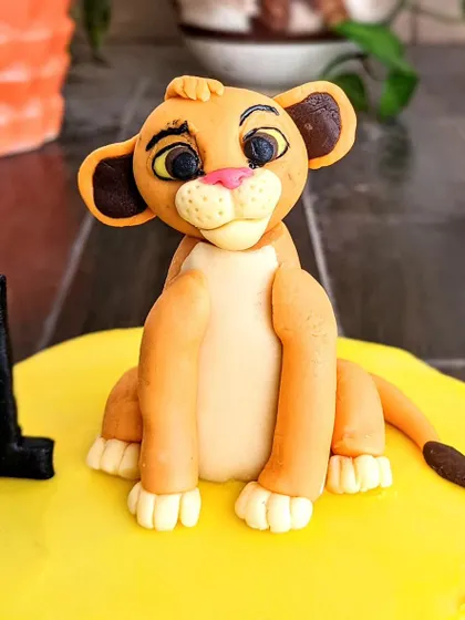 A different view of the fondant Simba, highlighting the careful layering of colors and the detailed work on his facial features. These toppers are fully edible and make a great centerpiece.
