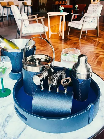 Our complete Bella Pelle Casa bar set in a sophisticated navy blue leather. This collection includes an ice bucket, shaker, bar tools, and a serving tray, making it the perfect gift for the modern host.
