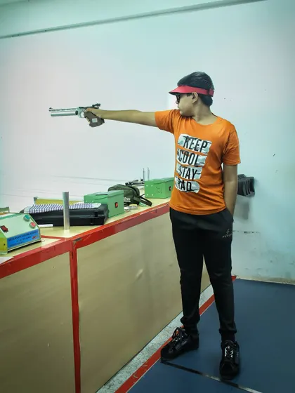 A young boy practices the correct one-handed stance for air pistol shooting. Proper form is key to accuracy and safety, which I emphasize in all my beginner classes.