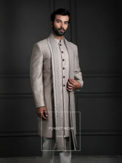 A closer look at the soft champagne jacquard sherwani. The clean lines, looped buttons, and mandarin collar are finished with a matching stole for a modern yet timeless look.