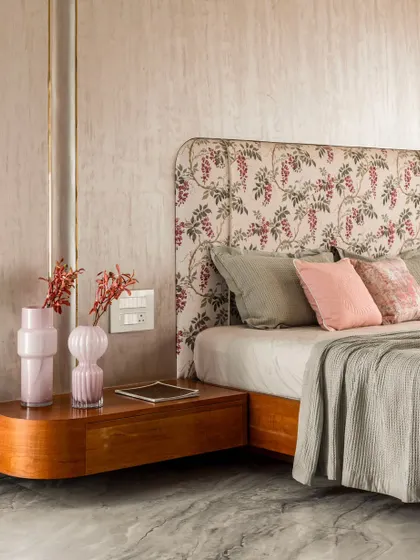 A closer look at the master bedroom's refined details. The floral headboard, curved wooden nightstand, and pastel hues create an interplay of elegance and movement within a calm architectural envelope.