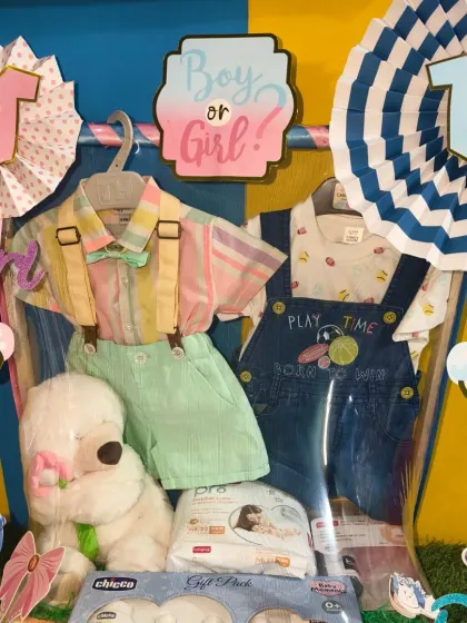 A fun 'Boy or Girl?' themed hamper for a baby shower. This one is filled with cute outfits, a soft toy, and baby care products.