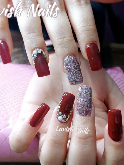 A sophisticated design in deep red, featuring accent nails with a dense arrangement of miniature pearls and a full-coverage holographic glitter nail.