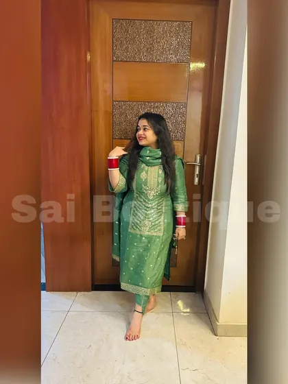 A client looking elegant in a green silk suit with delicate gold embroidery. A classic choice for any festive occasion.