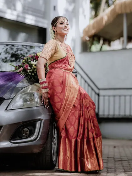 A stylish shot of the bride posing with a decorated wedding car. It's a modern and fun take on the classic bridal portrait.