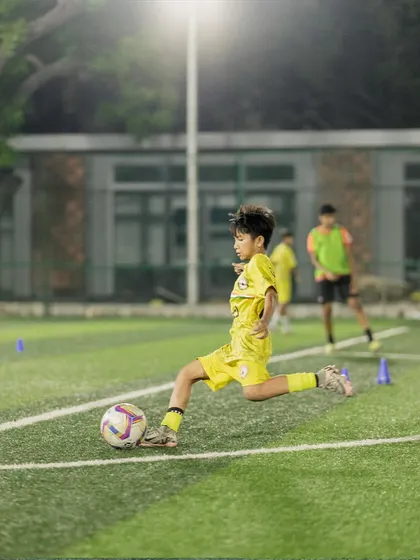 A young player practices his shooting technique during the special camp. Repetition and expert guidance are the keys to developing a powerful and accurate shot.