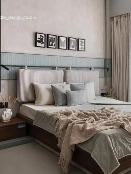 A wider shot of the Scandi-inspired bedroom, showing the full bed setup with its plush, layered bedding. The minimalist black reading light is a functional detail that adds to the room's contemporary aesthetic.