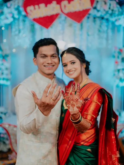 The happy couple proudly showing off their new engagement rings to the camera.