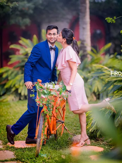 A playful and romantic moment with a bicycle in the garden, perfect for a fun-loving couple.