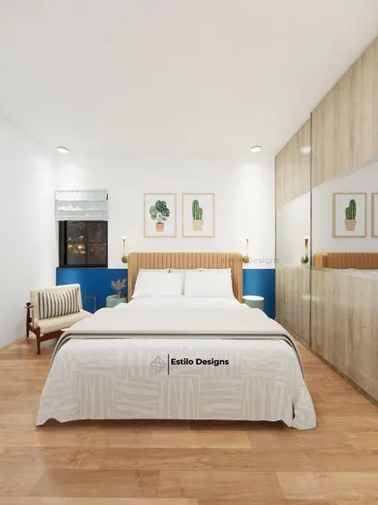 This guest bedroom is an exercise in minimalism, designed to be simple and functional. The room features a light wood wardrobe with mirrored panels to enhance the sense of space, complemented by a pop of blue on the accent wall.