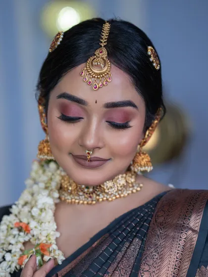 This shot beautifully captures the shimmer of the antique gold-plated jhumkas and choker, perfect for a traditional bride.
