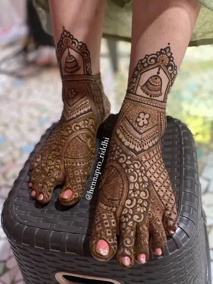 A design that is both simple and intricate. This foot henna combines delicate floral work with bold traditional shapes and bell motifs for a balanced and beautiful result.