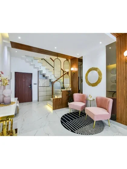 The full view of the Diamond District entryway, showcasing the marble floors, elegant staircase with custom paneling, and the inviting pink seating area that makes a refined first impression.