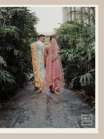 A quiet moment of the couple walking away, hand in hand, through a lush green pathway. This shot symbolizes their journey forward together.