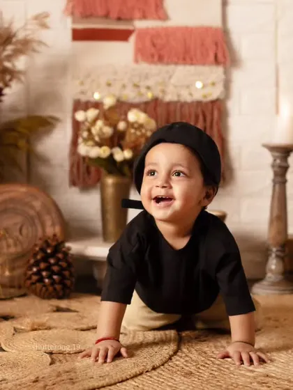 A happy baby crawling across a jute rug in our warm, earth-toned bohemian setup.