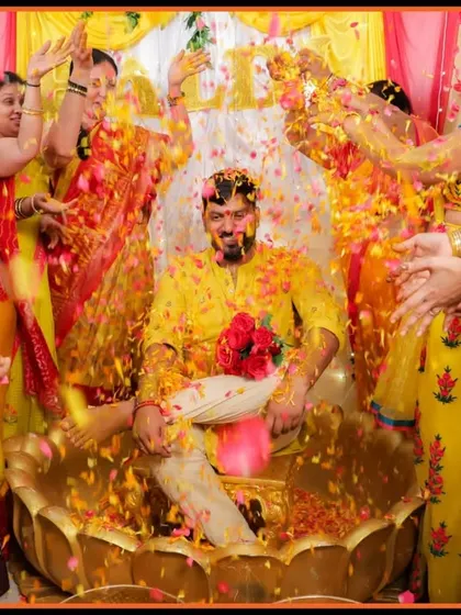A groom's Haldi ceremony in full swing, with friends and family showering him with flower petals. We capture the energy and excitement of these pre-wedding celebrations.