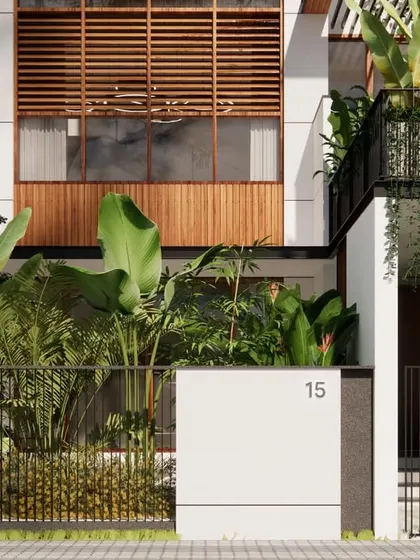 A ground-level detail of the Still House, focusing on the interplay between the crisp white walls, the warm wooden screens, and the vibrant tropical foliage.