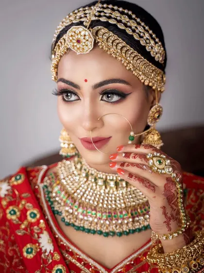 This bride is wearing a classic Kundan set with a beautiful matha patti. The intricate design and craftsmanship are evident in this close-up shot.