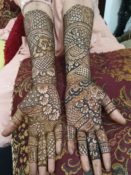 A rich and complex bridal design that extends well past the wrist. The palms are filled with a mix of florals and checks, creating a stunning visual for the bride.