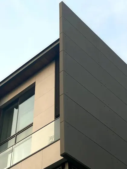 A close-up view of the building's sharp, angular profile against the sky. This detail showcases the precise execution of the facade panels and the clean lines that define the structure's modern aesthetic.