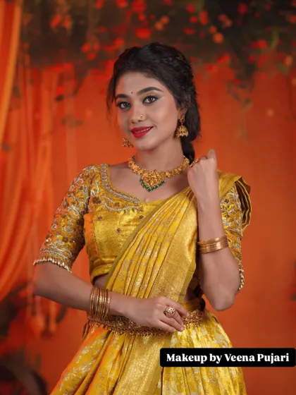 A bright and cheerful look. The makeup features a classic red lip and defined eyes, a perfect match for the vibrant yellow traditional outfit.