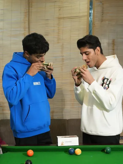 Good food, great company, and even better vibes. This picture shows two friends enjoying our wholesome sandwiches over a game of pool.