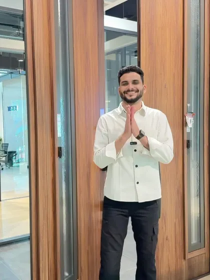 Standing in front of a grand Tostem steel main door. The wooden finish is so realistic, yet it offers the strength and security of steel. This door makes a powerful first impression while ensuring your home is protected. It's a perfect example of combining aesthetics with high-level functionality.