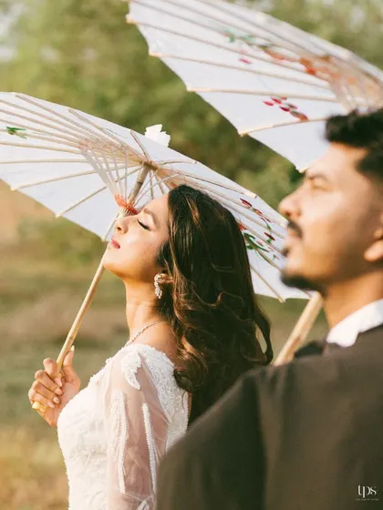 Frenzita and Abner in a serene, sun-drenched moment. The use of traditional parasols adds a touch of elegance and artistry to this outdoor pre-wedding portrait.
