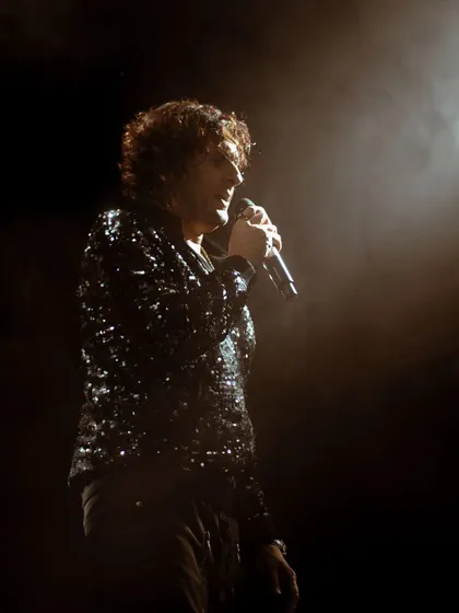 A portrait of the legendary Sonu Nigam, isolated by a single spotlight. This artistic shot focuses on the quiet intensity and emotion of the artist just before he delivers a powerful note.