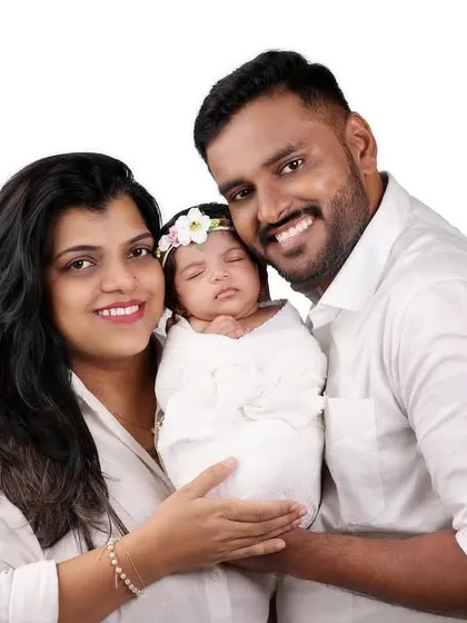 A classic family portrait against a clean white background. Their happy smiles and coordinated white outfits create a fresh and modern look.