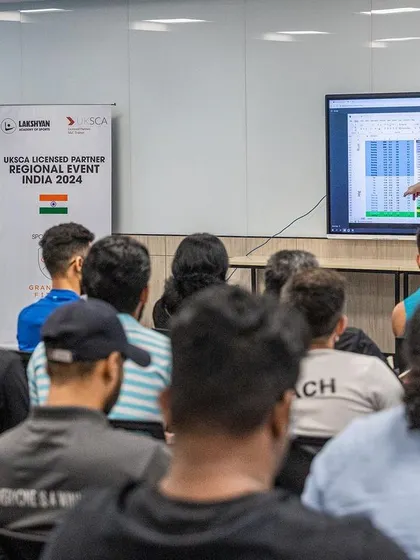A UKSCA trainer presents data on a screen, explaining how to interpret and apply performance metrics in a practical coaching context.