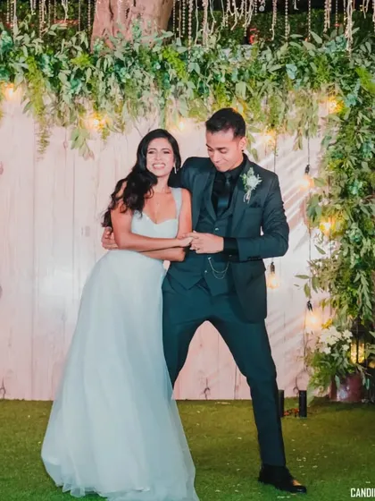 A fun, candid dance move from the couple during their reception party, showcasing their playful side.