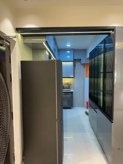 A view of a kitchen entrance, showing the seamless integration with the rest of the home's design. The grey cabinets and profile lighting create a sleek look.
