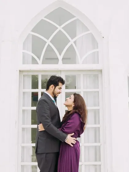 An elegant portrait in front of a white chapel-style building. This backdrop adds a touch of classic romance and sophistication to the pre-wedding shoot.