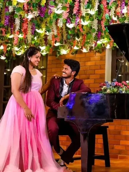 A sweet moment at a piano. The client's pink gown and her partner's suit create a classic, romantic scene.