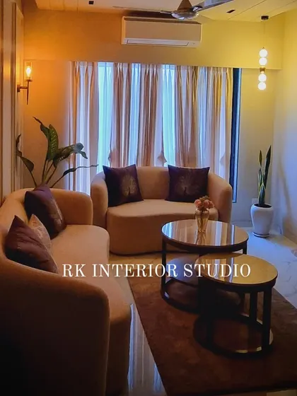 The same living room seen with warm, ambient lighting. The wall sconces and track lights create a cozy and inviting atmosphere in the evening.