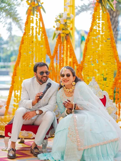 A candid moment of laughter during Palash and Palak's Haldi. The groom holding a mic adds a fun, interactive element to the ceremony, and I was there to capture their genuine smiles.