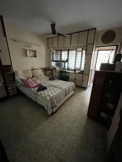 **BEFORE:** This guest bedroom had a small window and an enclosed balcony, limiting space and natural light.