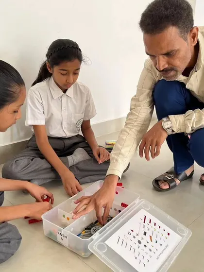 An instructor provides close guidance to two students at SVIS, ensuring they understand the task and are on the right track.
