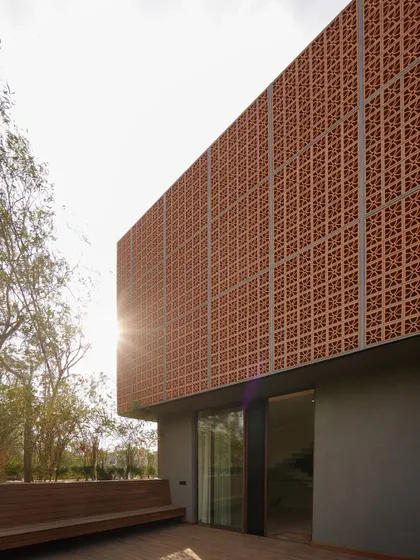 The Lantern House is a project where we transformed an existing structure into a private sanctuary. The signature terracotta 'jaali' screen acts as a protective veil, shielding the home from the harsh sun while creating a beautiful, glowing effect at night, embodying our approach to modern vernacular architecture.