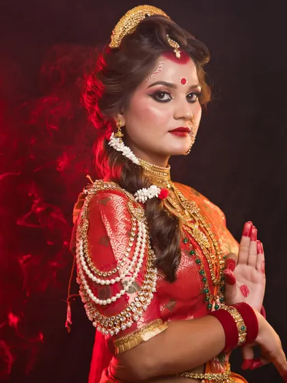 A stunning portrayal of Maa Chandraghanta, with intricate pearl arm jewellery and a powerful expression. The dramatic lighting adds to the mystique of the look.