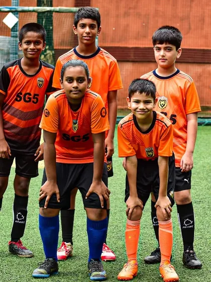 A youth team posing together on the pitch. The spirit of the game and the bonds of teamwork are our real wins.